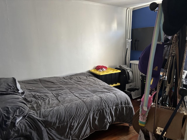 bedroom featuring ornamental molding and hardwood / wood-style floors