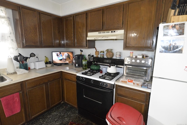 kitchen featuring gas stove and white fridge