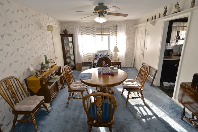 carpeted dining space with ceiling fan