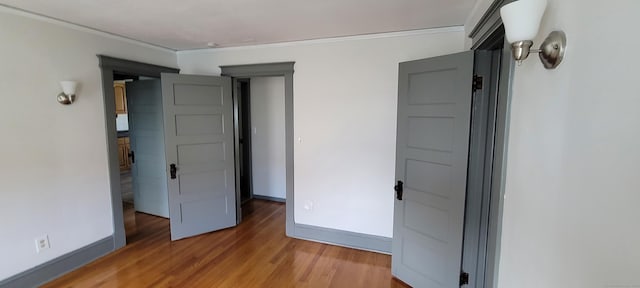 unfurnished bedroom with wood-type flooring and crown molding