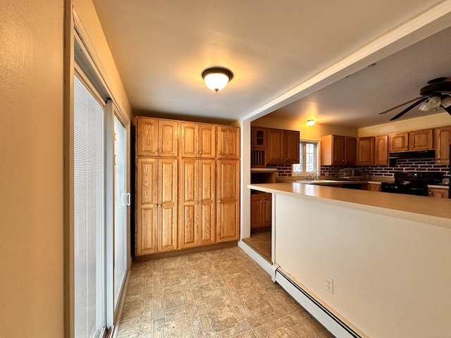 kitchen featuring extractor fan, black electric range oven, sink, backsplash, and baseboard heating