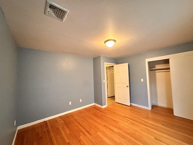 unfurnished bedroom featuring light wood-type flooring and a closet