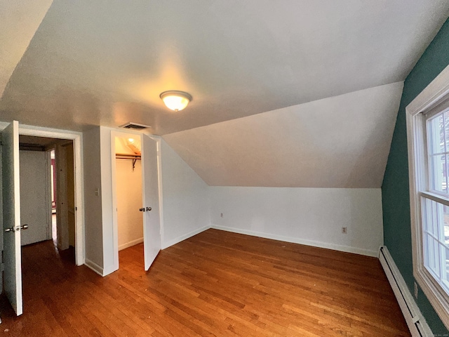 bonus room featuring vaulted ceiling, a baseboard heating unit, and hardwood / wood-style floors