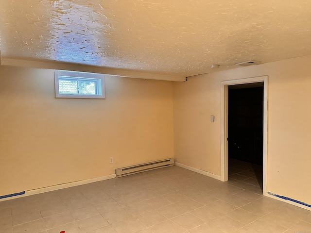 basement featuring a textured ceiling and a baseboard heating unit