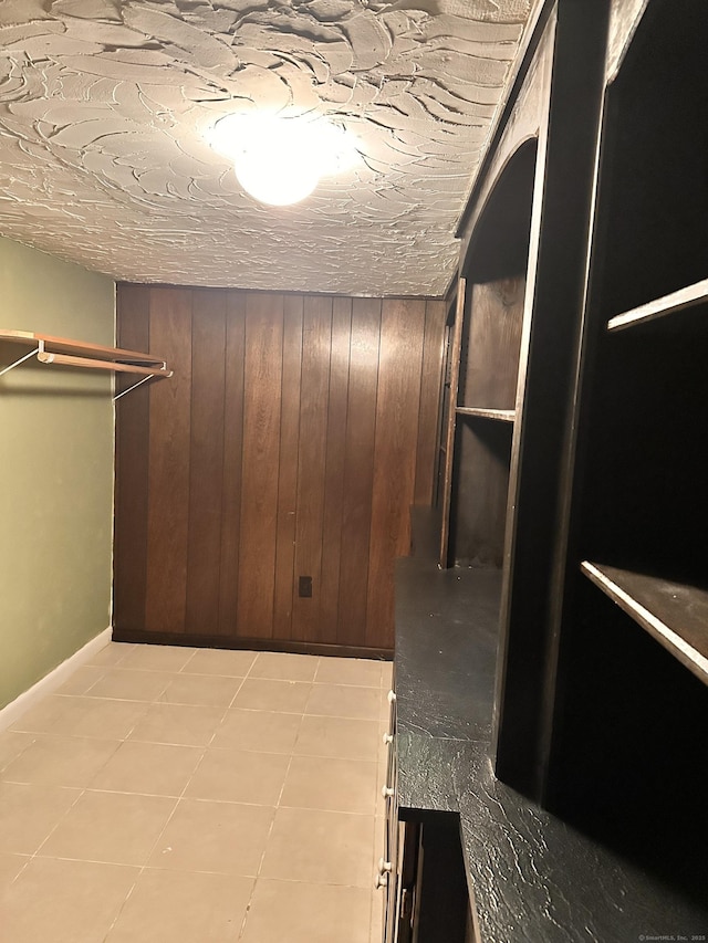 walk in closet with light tile patterned floors