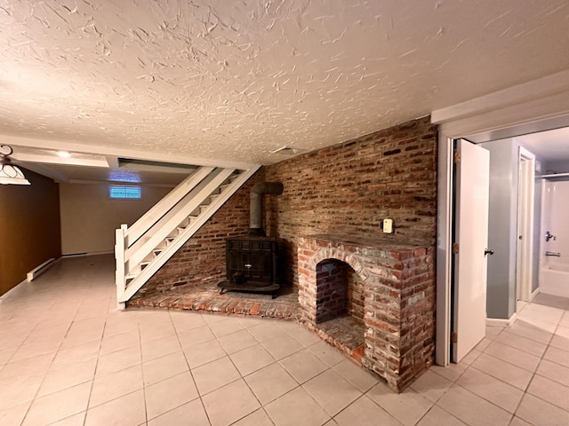 unfurnished living room with light tile patterned flooring, a wood stove, and a textured ceiling