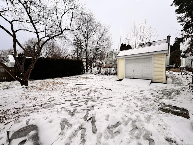 yard covered in snow with a garage and an outdoor structure