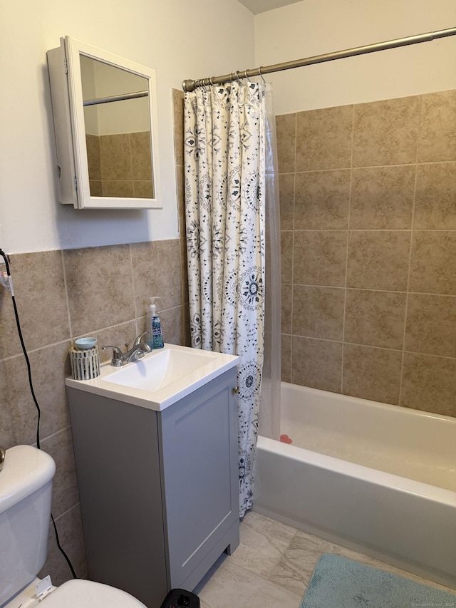 full bathroom featuring toilet, tile walls, vanity, and shower / bath combo with shower curtain