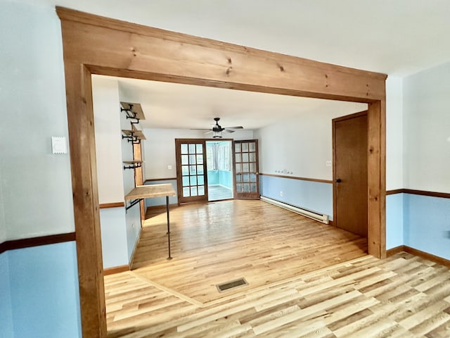 unfurnished room featuring beam ceiling, a baseboard radiator, ceiling fan, and light hardwood / wood-style floors