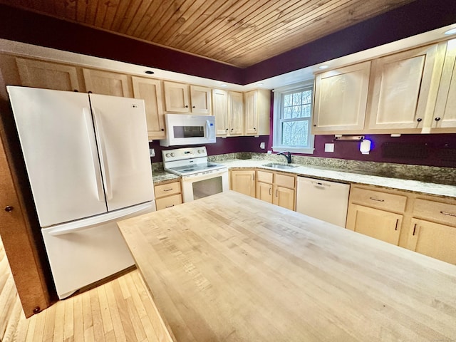 kitchen featuring butcher block countertops, sink, white appliances, and light brown cabinets