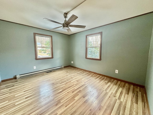 empty room featuring light hardwood / wood-style flooring, a wealth of natural light, and baseboard heating