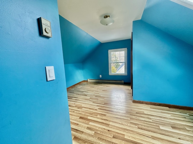 bonus room with vaulted ceiling, light hardwood / wood-style flooring, and a baseboard heating unit