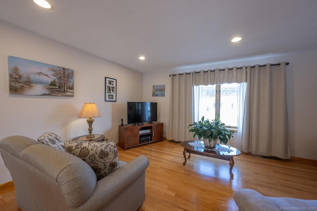 living room featuring light hardwood / wood-style flooring and a textured ceiling