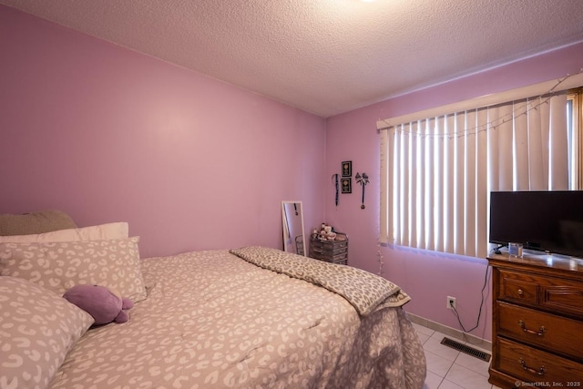 tiled bedroom featuring a textured ceiling