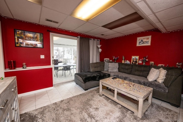 living room with light tile patterned flooring and a paneled ceiling