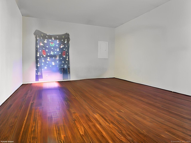 empty room featuring electric panel and hardwood / wood-style floors