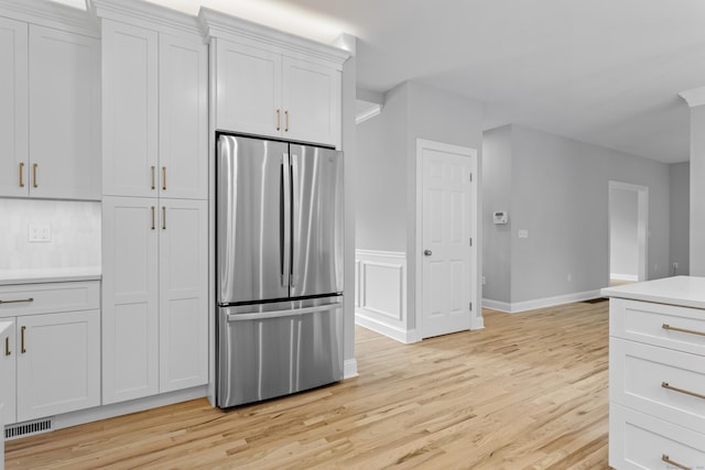 kitchen featuring white cabinetry, stainless steel fridge, and light hardwood / wood-style flooring