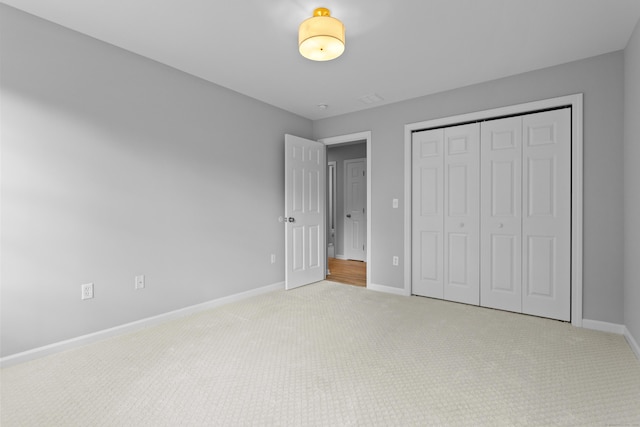 unfurnished bedroom with light carpet and a closet