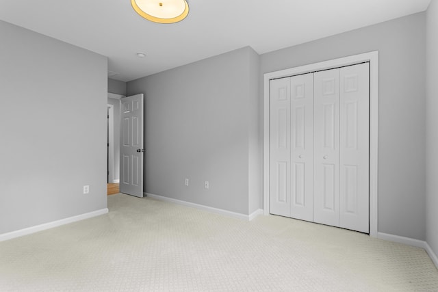 unfurnished bedroom featuring light colored carpet and a closet