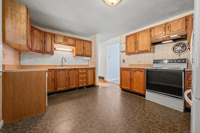 kitchen featuring brown cabinets, electric stove, and light countertops