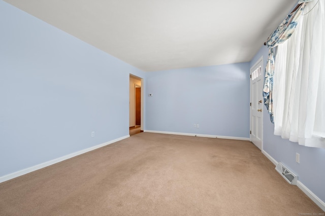 empty room featuring light carpet, baseboards, and visible vents