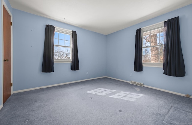 carpeted spare room with visible vents and baseboards