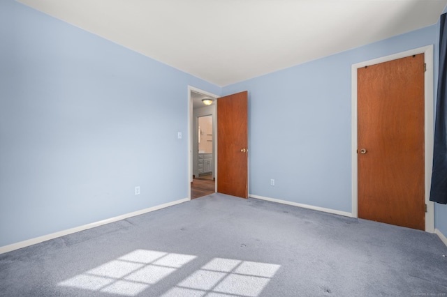 spare room featuring carpet floors and baseboards