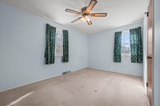 unfurnished room featuring carpet, visible vents, ceiling fan, and baseboards