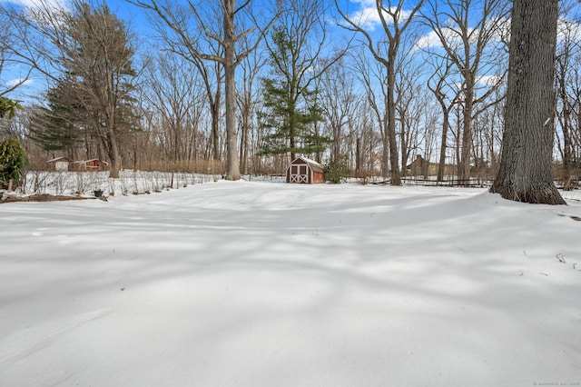 yard layered in snow with an outbuilding and a shed