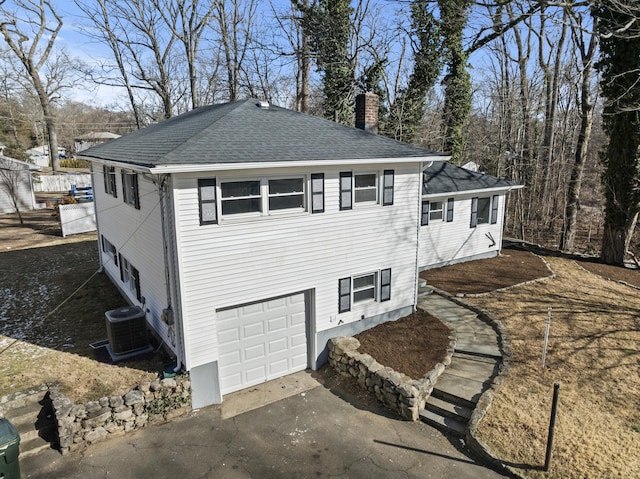 view of side of home featuring a garage and central air condition unit