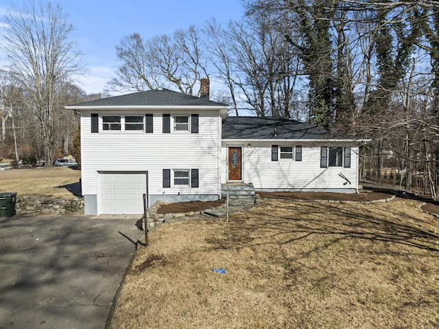 split level home featuring a garage and a front lawn