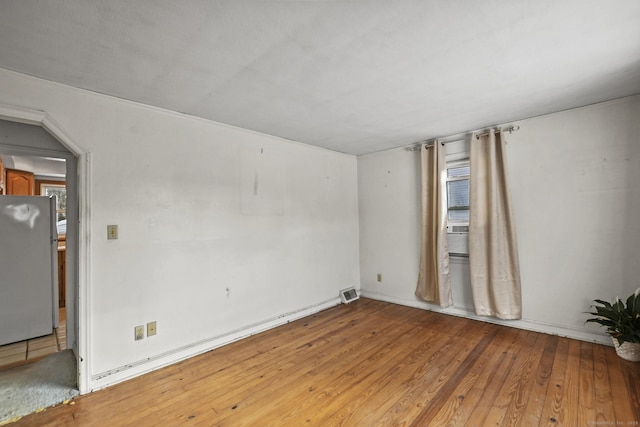 unfurnished room featuring visible vents and hardwood / wood-style floors