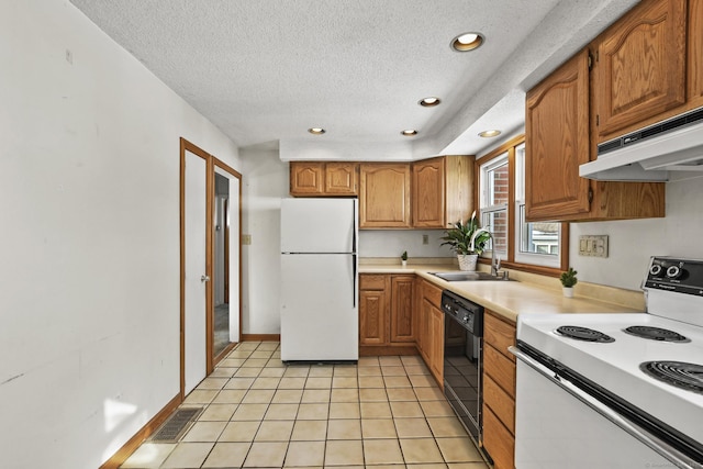 kitchen with light countertops, visible vents, a sink, white appliances, and under cabinet range hood