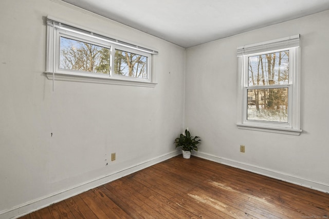 empty room with wood-type flooring and baseboards