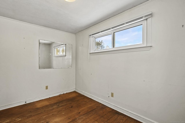 empty room featuring wood-type flooring and baseboards