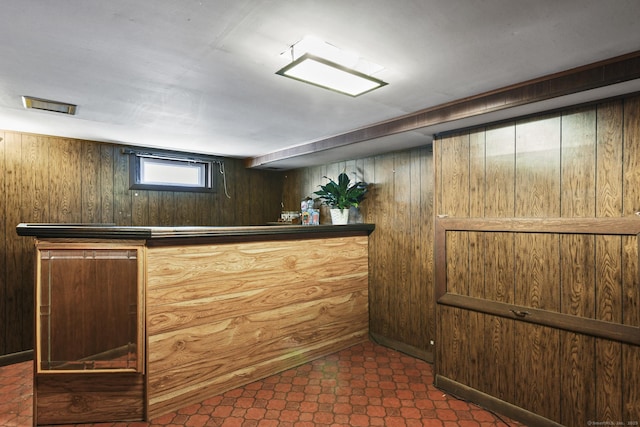 interior space featuring wood walls, a dry bar, and tile patterned floors