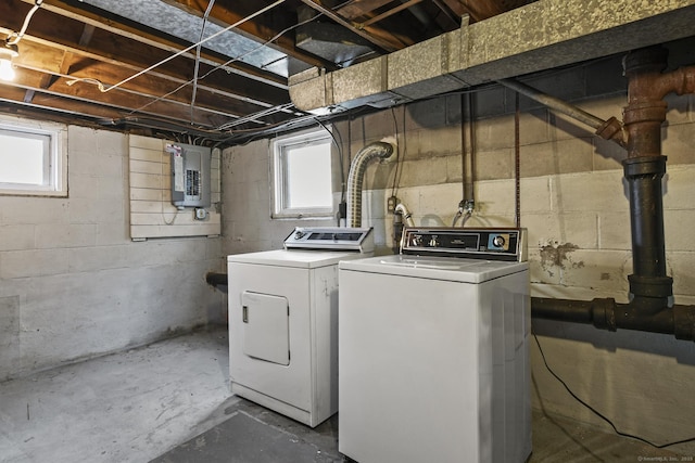 washroom with laundry area, a healthy amount of sunlight, electric panel, and washer and dryer