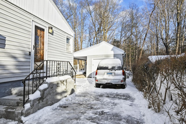 view of snowy exterior with a detached garage