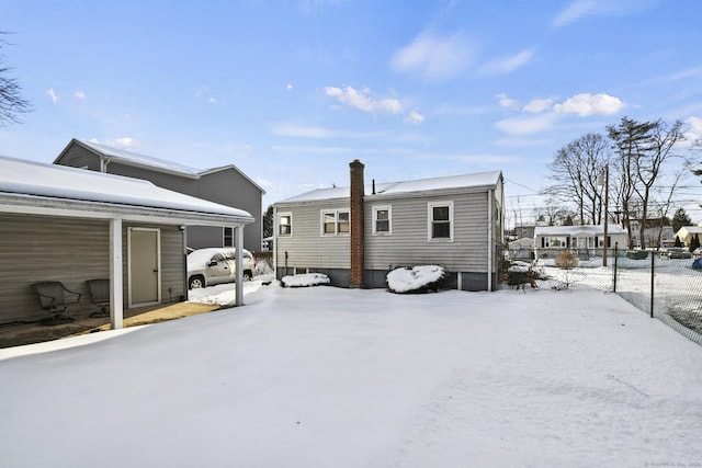 snow covered property with fence