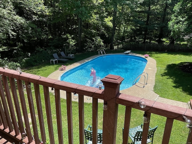 view of swimming pool featuring a yard