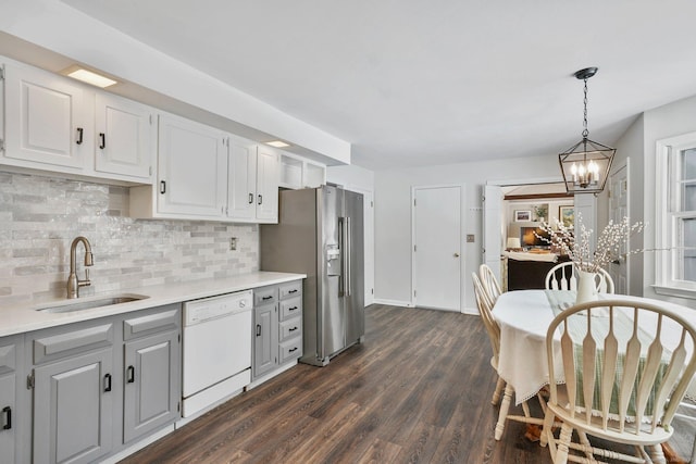 kitchen featuring sink, dishwasher, white cabinetry, hanging light fixtures, and high end refrigerator