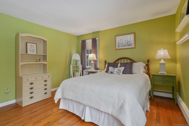 bedroom with hardwood / wood-style floors and baseboard heating