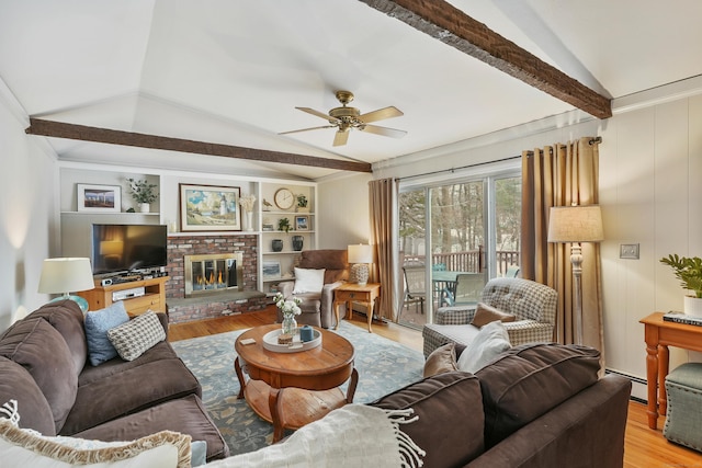 living room with a fireplace, lofted ceiling with beams, a baseboard radiator, ceiling fan, and light wood-type flooring