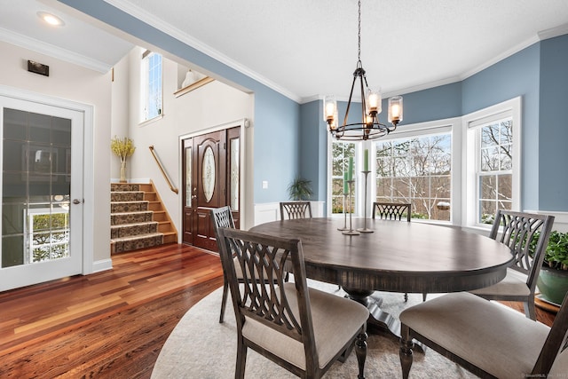 dining room featuring ornamental molding, dark hardwood / wood-style floors, a wealth of natural light, and an inviting chandelier