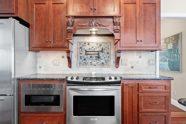 kitchen with stainless steel appliances, tasteful backsplash, hardwood / wood-style floors, and dark stone counters