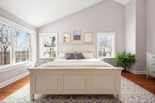 bedroom featuring multiple windows, vaulted ceiling, and hardwood / wood-style floors