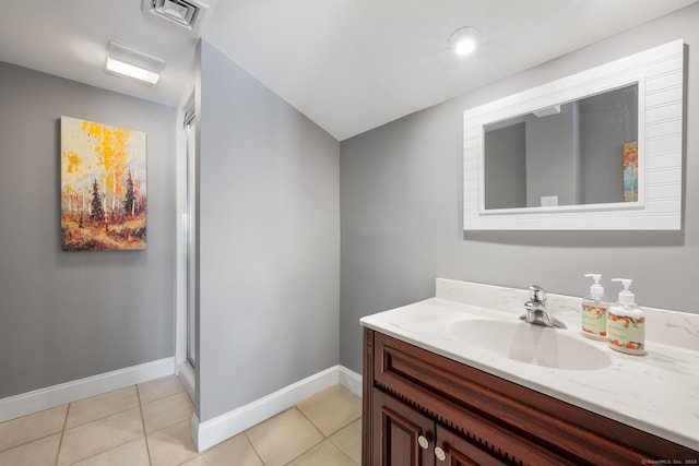 bathroom with tile patterned flooring, vanity, and a shower with door