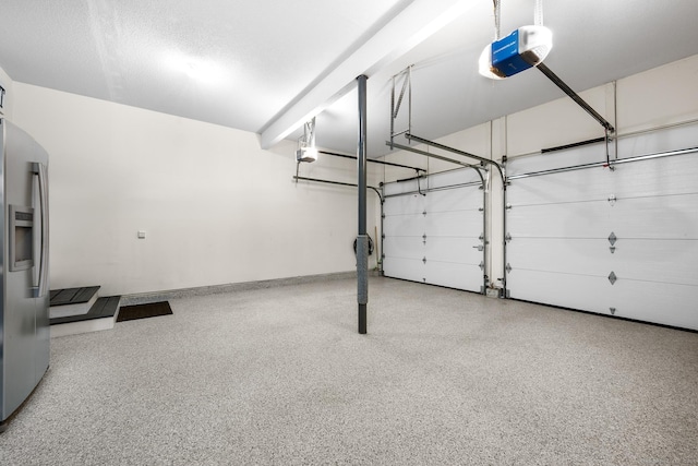 garage featuring a garage door opener and stainless steel fridge with ice dispenser