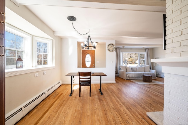 dining room featuring a baseboard heating unit, an inviting chandelier, and light hardwood / wood-style floors