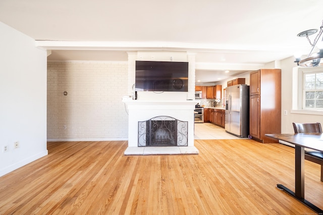 unfurnished living room with brick wall and light wood-type flooring